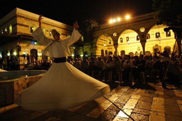 2008 г. Покупатели рынка в Алеппо наблюдают за танцем дервиша