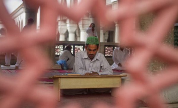 Пакистанец читает Коран в мечети до начала ифтара