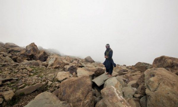 Житель Кашмира совершает намаз на скалах у пограничной линии