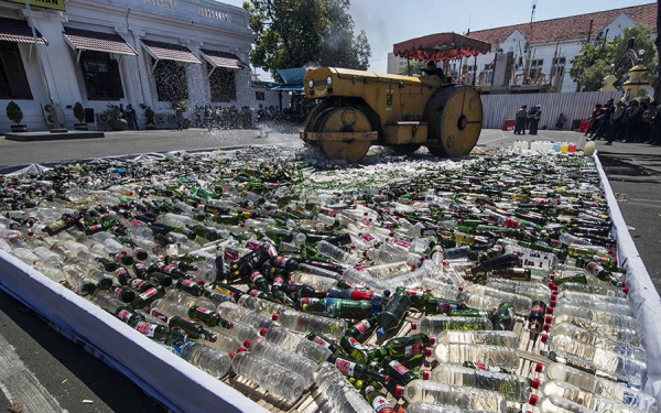 Каток раздавил около 100 000 бутылок с алкоголем во дворе городского полицейского участка
