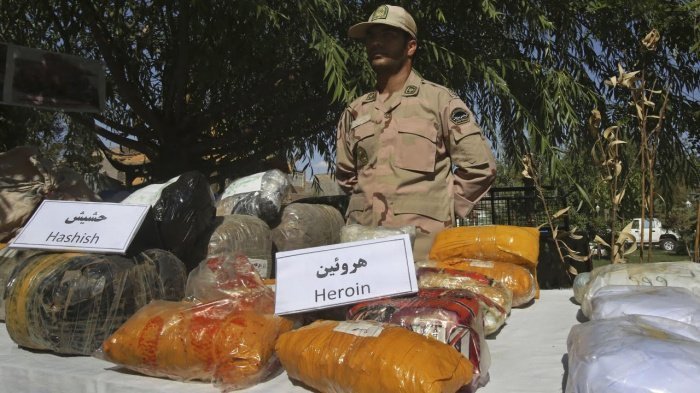 Иранский наркополицейский с изъятыми веществами перед их уничтожением. (Фото: yandex.ru). 