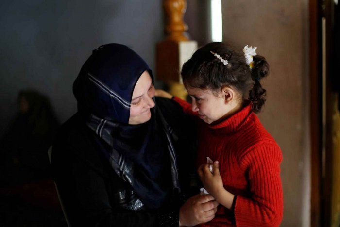 Нивиин Баракат утешает дочь Русуль в секторе Газа. Муж Нивиин умер во время взрыва школы в Газа. Бомба ранила троих ее детей, включая 6-летнюю Русуль, и приковала Нивиин к инвалидному креслу. © UNICEF/UNI179600/El Baba 