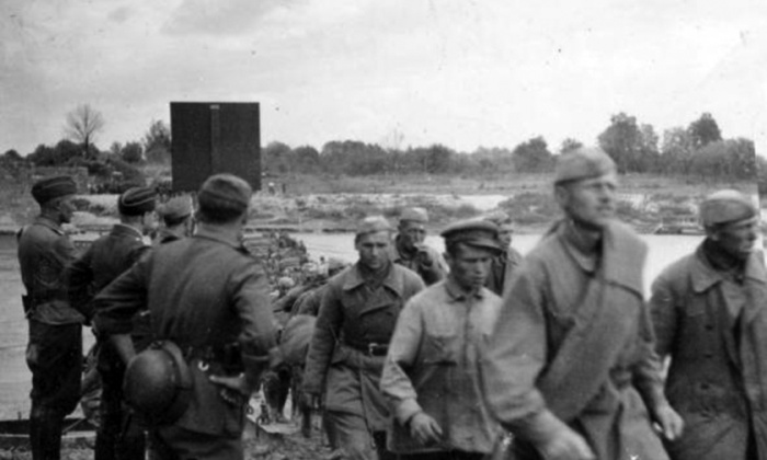 Первые советские военнопленные под наблюдением немецких солдат направляются на запад по мосту через реку Сан у города Ярослав. 22 июня 1941 г. (Фото: pravmir.ru).
