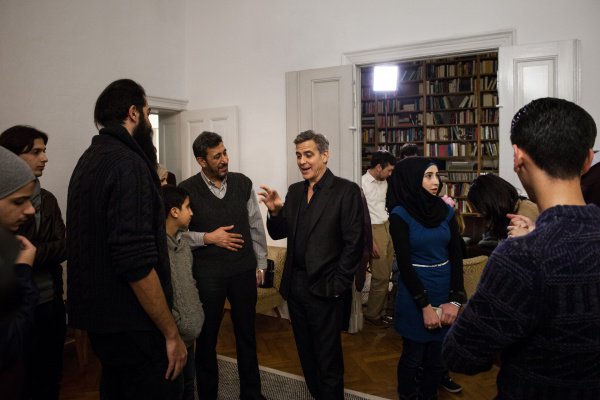 Джордж Клуни беседует с беженцами.